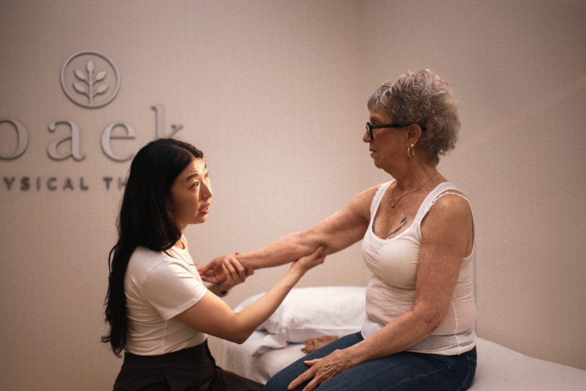 Dr. Carolyn Baek assessing a patient's arm during a treatment session