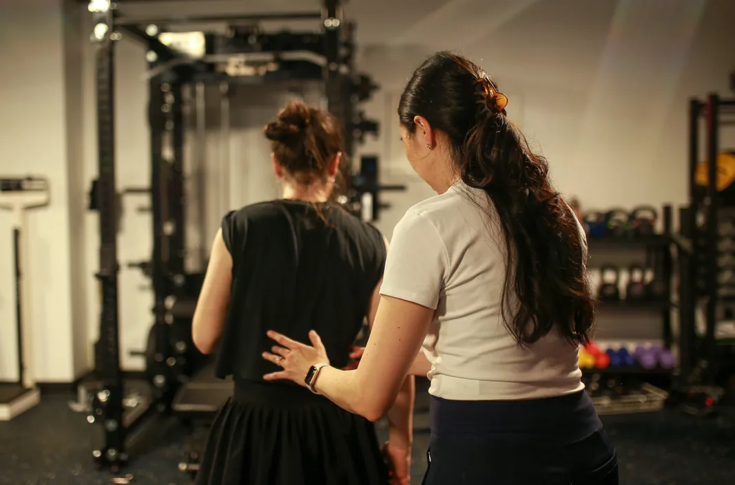Dr. Baek coaching a patient through movement in the gym