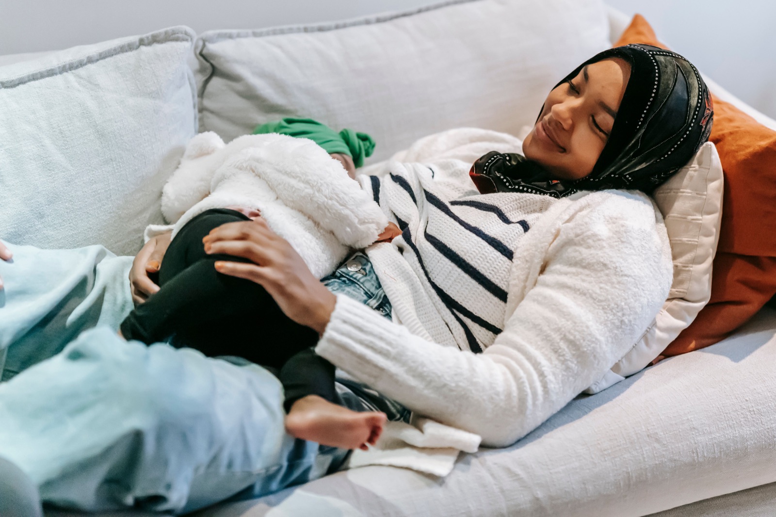 Mother resting on the couch with her baby