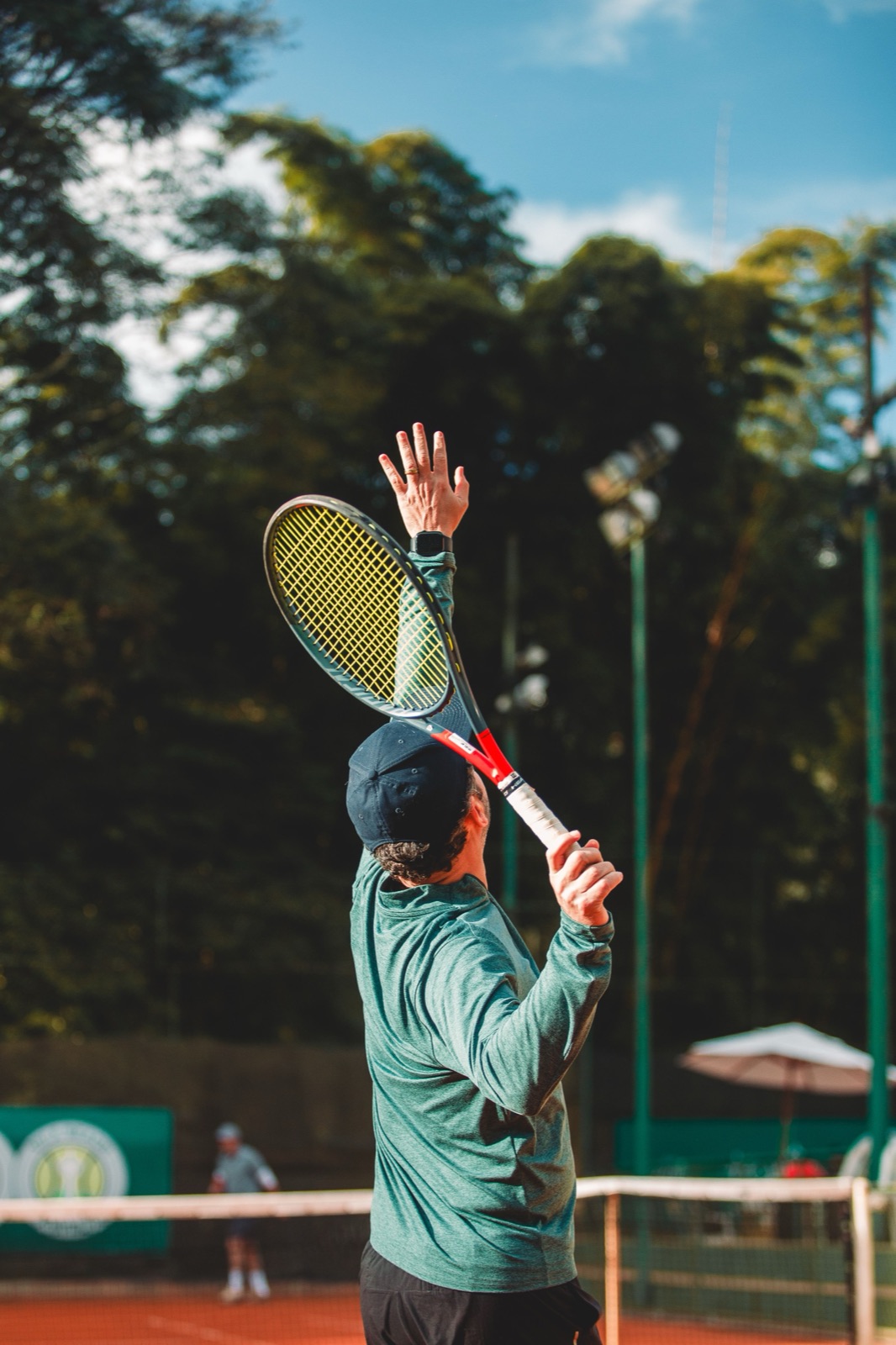 Tennis player serving on a clay court